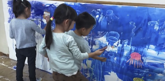  発光する深海魚に興味を持った子供たちの写真